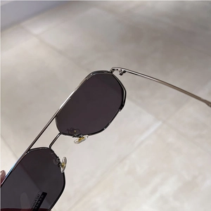Detail of gunmetal geometric sunglasses with TAC polarized lenses and double bridge design