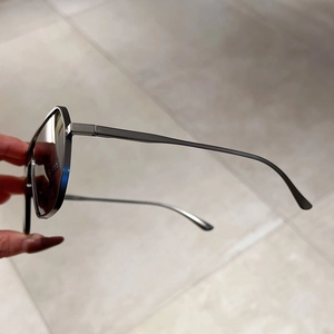 Detail view of stylish metallic gunmetal polygon frame with sleek metal temples