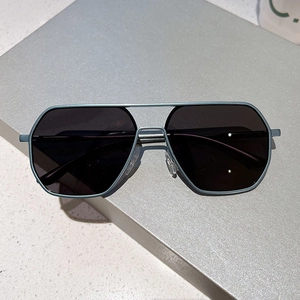 Modern polygon blue metal frame sunglasses with dark grey lenses on a grey platform