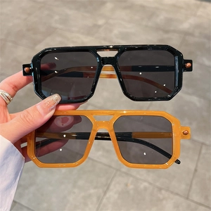 Detailed close-up of geometric square sunglasses with double-bridge frame in black and orange