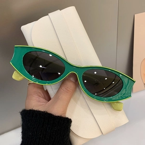 Modern emerald green cat-eye sunglasses with dark grey lenses and matching case