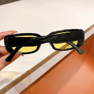 Close-up of vintage square black sunglasses with transparent yellow lenses in hand