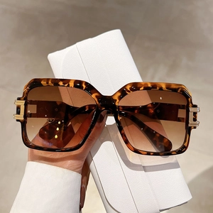 Close-up of tortoise shell square sunglasses with brown lenses and leather pouch