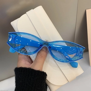 Detailed shot of cat-eye sunglasses with blue glitter translucent frame on a case