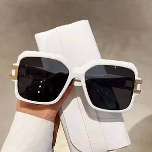 Close-up of square white sunglasses with golden H-hinge and white leather case