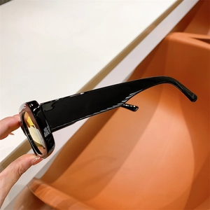 Detail of vintage square sunglasses with glossy black frame and tinted tea-colored lenses