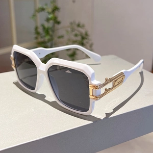 Detail of white square sunglasses with golden metal hollow-out temple decorations