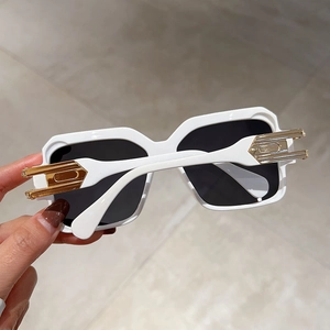 Detail of white square sunglasses with a luxury gold hollowed metal hinge design