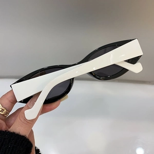 Close-up of retro cat-eye sunglasses with thick white frames and black lenses