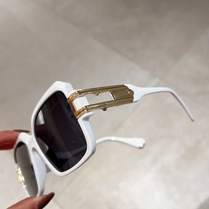 Detail of white square sunglasses with golden metal hollow hardware on the temple