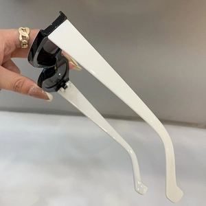 Detail view of stylish wide-leg cat eye sunglasses with black and white color block frame