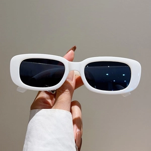 Detail view of stylish rectangular white sunglasses with premium thick frame and dark lenses