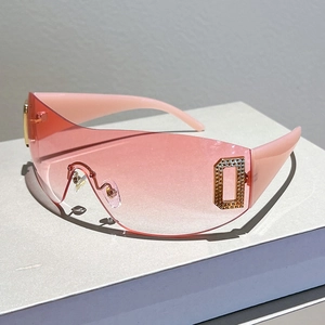 Detail of pink gradient shield lens with sparkling rhinestone D logo and gold hinge