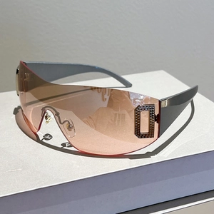 Detailed shot of Y2K shield sunglasses with pink gradient lens and rhinestone D logo