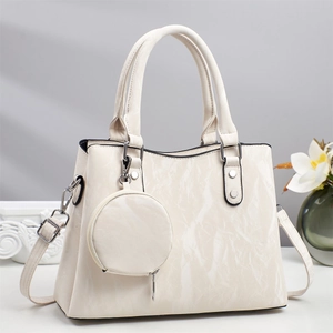 White textured leather tote bag with double handles and round coin purse accessory