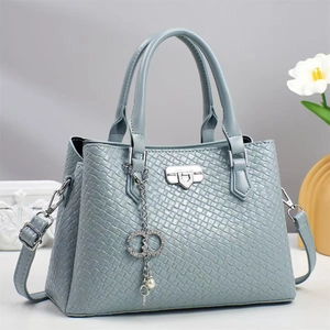 Light blue woven texture tote bag with silver hardware and pearls on a grey background
