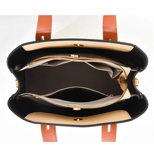 Top view of caramel leather tote bag interior showing multiple compartments and zip pocket