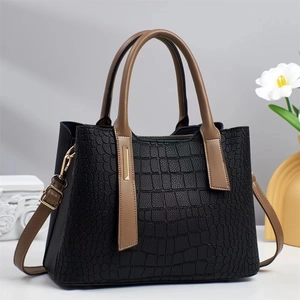 Sac à main noir texture crocodile élégant avec anses marron sur fond minimaliste chic