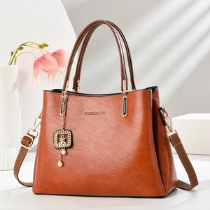 Vintage brown leather trapezoid tote bag with gold pearl pendant and dual handles