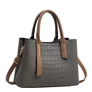 Sac à main gris à motif crocodile avec poignées marron et détails dorés