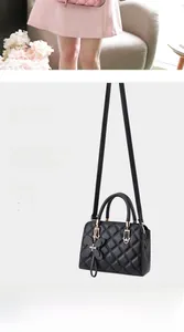 Close-up of quilted black leather handbag with a decorative butterfly charm and strap