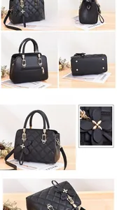 Detail view of black quilted crossbody bag with gold hardware and butterfly charm