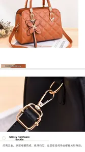 Detail of glossy gold-plated hardware and floral charm on quilted leather handbag