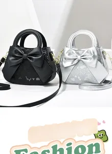 Détail de sacs à main en cuir serpent avec grand nœud décoratif en noir et argent