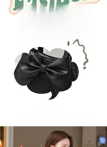 Gros plan du sac bandoulière noir avec un grand nœud en cuir et texture serpent