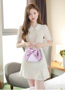 Gros plan du sac à main violet pour femme avec grand nœud 3D et similicuir texturé