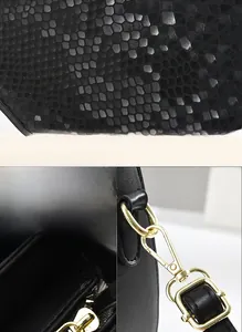 Détails du cuir noir à motif serpent embossé et des accessoires métalliques dorés
