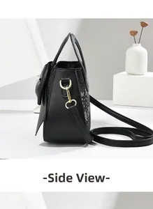 Vue latérale du sac noir en cuir avec motif serpent et détail de nœud papillon