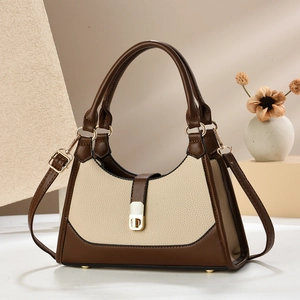 Détail du sac en cuir beige et marron avec fermoir tournant doré et bandoulière