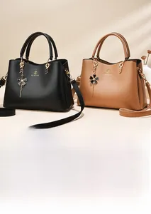 Detail of luxury leather handbags in black and brown with gold flower charm
