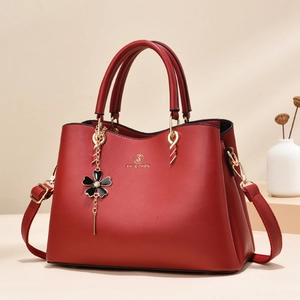 Red lychee texture tote bag for women with gold logo and elegant floral pendant accessory