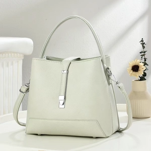 Detailed view of mint green pebble leather bucket bag with silver metal buckle and handle