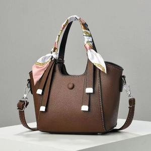 Brown lychee leather handbag detail with decorative silk scarf and silver hardware