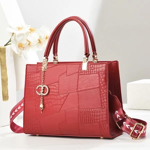 Red crocodile texture handbag with wide jacquard strap and gold charm ornament