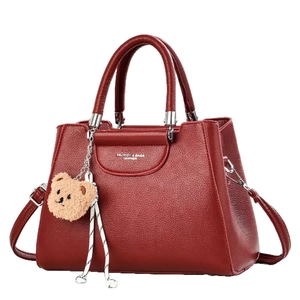 Dark red lychee pattern leather handbag with metal handles and a bear charm accessory