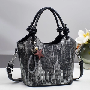 Chic silver sequin bucket bag with knotted black leather handles and star charm