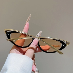 Detail einer Cat-Eye-Sonnenbrille mit goldfarbenen Knotengelenken und braunen Gläsern