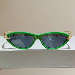 Detailansicht der grünen Cat-Eye-Sonnenbrille mit goldener Kettenverzierung am Bügel
