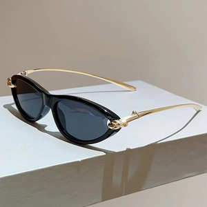 Nahaufnahme der Vintage-Cat-Eye-Sonnenbrille mit goldenen Knotenbügeln und schwarzem Rahmen