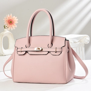Sac à main rose pâle grainé avec fermoir doré et bandoulière sur fond blanc minimaliste
