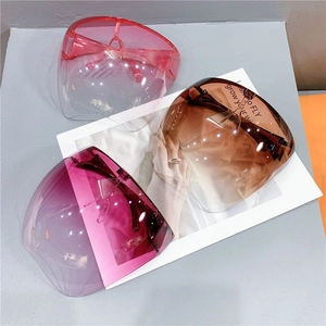 Three gradient anti-fog face shields in pink, brown, and purple on a minimalist surface