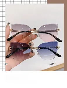 Détail de lunettes de soleil œil de chat sans monture avec verres dégradés rose et bleu