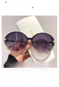 Detail of gradient frame sunglasses with golden leaf metal accents and textured temples
