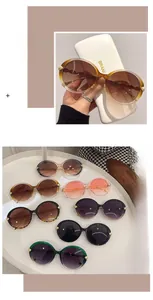 Detail of round oversized sunglasses featuring golden leaf accents and multi-color frames