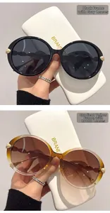 Detail of round sunglasses with wavy temples and golden leaf metal accents on the hinges