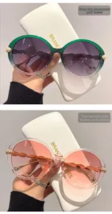 Detail of round sunglasses with gradient frames and golden leaf accents on the temples